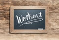 Workout Written on Slate Chalk Board Against Aged Wood Background Royalty Free Stock Photo