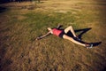 That workout really knocked her out. a sporty young woman taking a break while exercising outdoors. Royalty Free Stock Photo