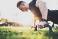 Workout lifestyle concept.Muscular athlete exercising push up outside in sunny park. Fit shirtless male fitness model in Royalty Free Stock Photo