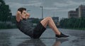 workout muscular man doing sit ups in rain Royalty Free Stock Photo