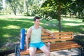 Workout is over. Man with yoga mat and water bottle sit on bench in park. Join outdoors yoga practice. Athlete with yoga Royalty Free Stock Photo