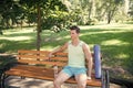 Workout is over. Man with yoga mat and water bottle sit on bench in park. Join outdoors yoga practice. Athlete with yoga Royalty Free Stock Photo