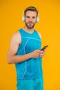 Workout phone for fitness fanatic. Fit guy listen to music on mobile phone. Using phone apps for sports training. Modern