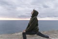 Workout on a rock, attractive slim woman doing stretching in nature over the sea. Wellness training outdoors in Royalty Free Stock Photo