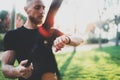 Workout smart lifestyle concept.Bearded muscular athlete doing great exercising TRX outside in summer park.Young