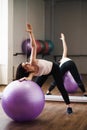 Fit woman doing pilates exercise using ball in gym Royalty Free Stock Photo