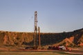 Workover rig working on a previously drilled well trying to restore production through repair in Western Oklahoma with sunset refl