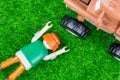 Workplace accident simulation with a playmobil lying on the ground and a tractor next to him