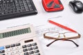 Workplace of accountant: invoice, keyboard, calculator, mouse, hole punch, glasses and red pen Royalty Free Stock Photo