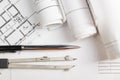 Workplace of architect - Architectural project, blueprints, rolls and pen, divider compass on plans. Engineering tools Royalty Free Stock Photo