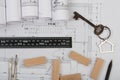 Workplace of architect - key with trinket in the shape of a house, wooden blocks, construction drawings, engineering tools Royalty Free Stock Photo