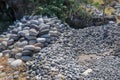 Workplace of Balinese stone gatherers. Sorted boulders by size. Natural building material. Hard work. Stones thrown from the sea a Royalty Free Stock Photo