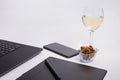 Workplace with black laptop computer, digital graphic tablet and pen, smart phone, dry grapes and glass white wine on white backgr Royalty Free Stock Photo