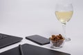 Workplace with black laptop computer, digital graphic tablet and pen, smart phone, dry grapes and glass white wine on white backgr Royalty Free Stock Photo