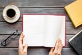 Workplace with book in hands for reading, glasses, coffee on wooden background flatlay