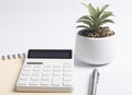 Workplace with calculator, notebook, pen and green potted plant. Business and finance concept Royalty Free Stock Photo