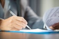 Workplace closeup person professional businesswoman sitting at desk hold pen signing or signature contract paper. Employee woman Royalty Free Stock Photo