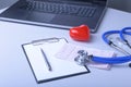 Workplace of doctor with laptop, stethoscope, red heart and RX prescription on white table. top view. Royalty Free Stock Photo