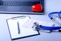 Workplace of doctor with laptop, stethoscope, red heart and RX prescription on white table. top view. Royalty Free Stock Photo