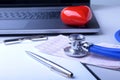 Workplace of doctor with laptop, stethoscope, red heart and RX prescription on white table. top view. Royalty Free Stock Photo