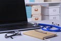 Workplace of doctor with laptop, stethoscope, RX prescription, glasses and notebook on white table. Copy space.