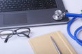 Workplace of doctor with laptop, stethoscope, RX prescription, glasses and red heart and notebook on white table. Copy Royalty Free Stock Photo