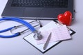 Workplace of doctor with laptop, stethoscope, RX prescription, glasses and red heart and notebook on white table. top Royalty Free Stock Photo