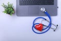 Workplace of doctor with laptop, stethoscope, RX prescription, glasses and red heart and notebook on white table. top Royalty Free Stock Photo