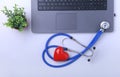 Workplace of doctor with laptop, stethoscope, RX prescription, glasses and red heart and notebook on white table. top Royalty Free Stock Photo