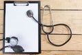 Workplace of a doctor. Medical clipboard and stethoscope on wooden desk background. Top view Royalty Free Stock Photo