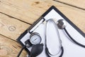 Workplace of a doctor. Medical clipboard and stethoscope on wooden desk background. Top view Royalty Free Stock Photo