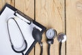 Workplace of a doctor. Medical clipboard and stethoscope on wooden desk background. Top view Royalty Free Stock Photo