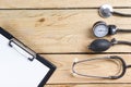 Workplace of a doctor. Medical clipboard and stethoscope on wooden desk background. Top view Royalty Free Stock Photo