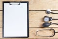 Workplace of a doctor. Medical clipboard and stethoscope on wooden desk background. Top view Royalty Free Stock Photo