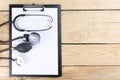 Workplace of a doctor. Medical clipboard and stethoscope on wooden desk background. Top view Royalty Free Stock Photo