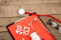 Workplace of a doctor. Stethoscope, clipboard, glasses and pills on a wooden desk Royalty Free Stock Photo