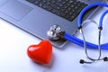 Workplace of doctor with stethoscope, red heart, laptop, rx prescription and notebook on white table. top view.