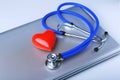 Workplace of doctor with stethoscope, red heart, laptop, rx prescription and notebook on white table. top view.