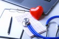 Workplace of doctor with stethoscope, red heart, laptop, rx prescription and notebook on white table. top view.