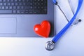 Workplace of doctor with stethoscope, red heart, laptop, rx prescription and notebook on white table. top view.