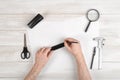 Workplace of draftsman with pencil, pen, stapler, scissors, magnifying glass. Man hands holding centimeter ruler and Royalty Free Stock Photo