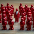 Workplace dynamics red doll amid others symbolizes discussions or leadership Royalty Free Stock Photo