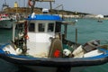 Daily workplace of a fisherman: blue and white fishing vessel on the ocean with net and fishing utilities