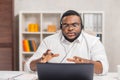 Workplace of freelancer. African-American man works at home office using computer, headset and other devices. Employee Royalty Free Stock Photo