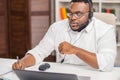 Workplace of freelancer. African-American man works at home office using computer, headset and other devices. Employee Royalty Free Stock Photo