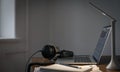 Workplace with headphones and laptop in the evening, copy space. Royalty Free Stock Photo