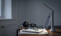 Workplace with headphones and laptop in the evening, copy space. Royalty Free Stock Photo