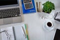 Workplace. A laptop, a calculator, notebooks and a cup of coffee on a white desktop Royalty Free Stock Photo