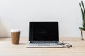 workplace with laptop computer eyeglasses and disposable cup of coffee Royalty Free Stock Photo