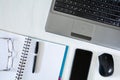 Workplace. A laptop with a mouse, a notebook with a pen and a smartphone on a white desktop